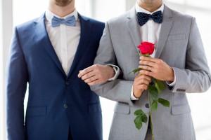 close up of happy male gay couple holding hands