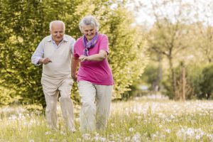 Playful senior couple having fun in nature while chasing.